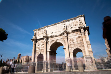 Fototapeta na wymiar Arco of Costantino in Rome. Costantine arch of triumph in Rome with tourist moving fast around it