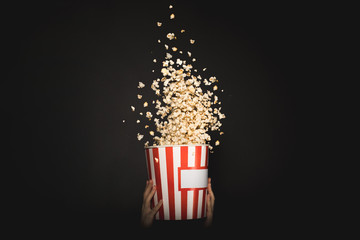 woman holding bucket of popcorn