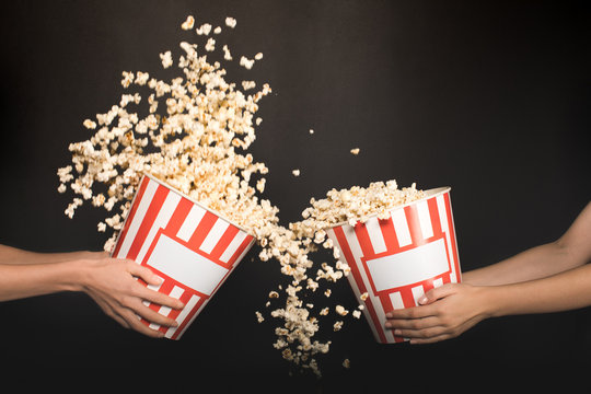 People Spilling Out Popcorn From Buckets