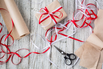 Celebratory concept - set with handmade present box in kraft paper, wrapping tools, packing paper...