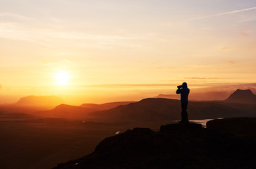 Nature photographer with digital camera on top of the mountain.