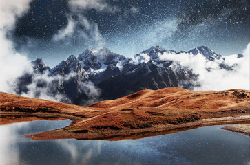 Fantastic starry sky on mountain lake Koruldi. Picturesque night Upper Svaneti, Georgia Europe....