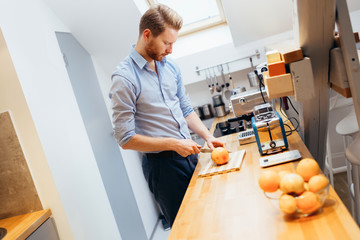 Man slicing oranges in kitchen