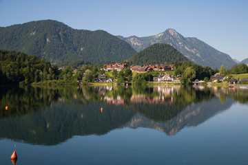 Fototapeta na wymiar Der Ort Grundlsee Bräuhof mit wunderschön gespiegeltem Grundlsee am Morgen