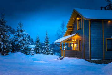 Snow-covered cottage. Wooden two-storey cottage. Winter.