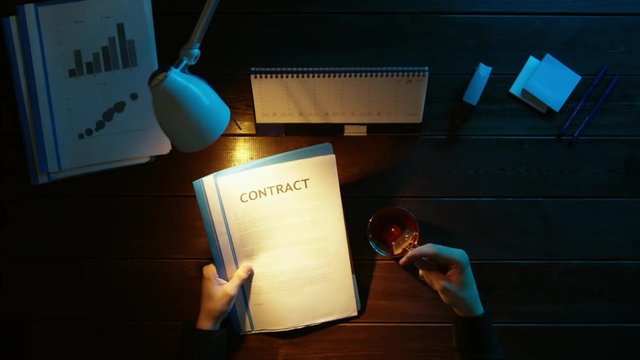 A man is sitting at an office desk and using a phone.