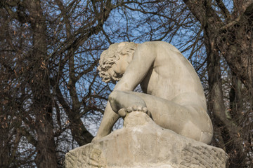 Sculpture of The Dying Gladiator, showing a naked wounded man with the neck torc, 1783 by Franciszek Pinck in the Royal Baths Park, Warsaw, Poland - obrazy, fototapety, plakaty