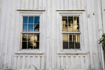 Old windows in a Norwegian house with white wood planks. Very old house wall. texture