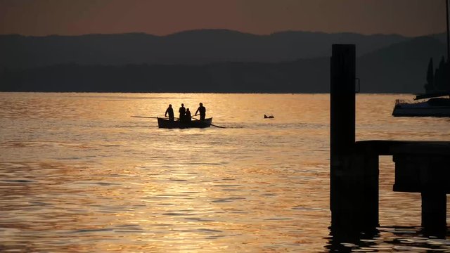 Barca a remi pescatori sul lago di Garda al tramonto