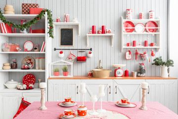 Interior light grey kitchen and red christmas decor. Preparing lunch at home on the kitchen concept.
