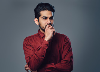 An Indian male dressed in a red shirt.