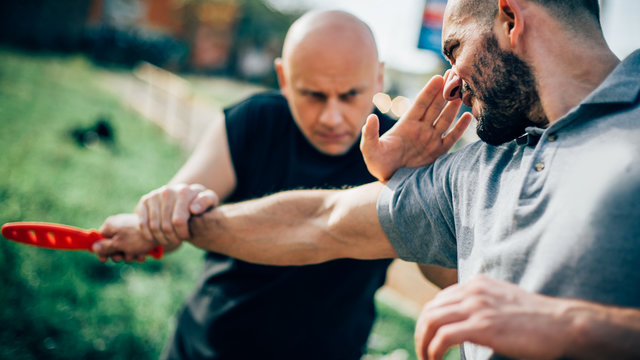 Self defense disarming technique against threat and knife attack