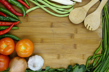 Top view of wooden cooking table with empty space and surrounded by various groceries. Cooking concept.