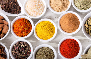 various spices and herbs for cooking on a wooden table