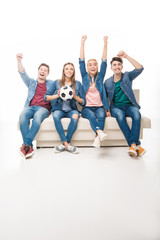 Obraz premium friends with soccer ball sitting on sofa