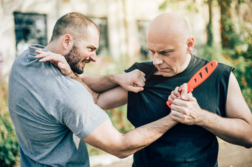 Self defense disarming technique against threat and knife attack