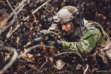 soldiers or private military contractors aiming with rifle. war, army, weapon, technology and people concept.