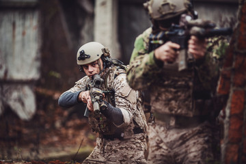 Fototapeta premium soldiers or private military contractors aiming with rifle. war, army, weapon, technology and people concept.