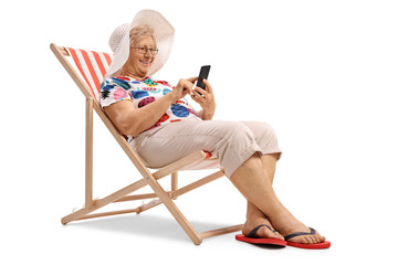 Elderly woman sitting in a deck chair and looking at a phone