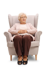 Elderly woman sitting in an armchair and looking at the camera