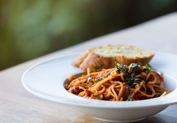 spaghetti bolognese with garlic bread wooden table