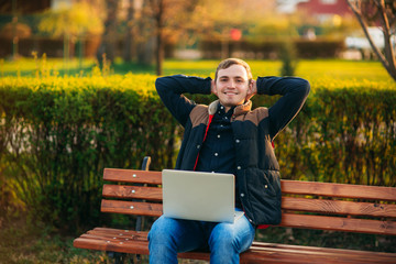 Fototapeta premium The young manager working on a laptop in the park. Lunch Break.