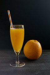 Freshly squeezed orange juice on a dark background.