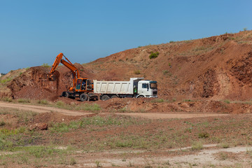 excavator loads a truck with rock rock