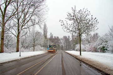 Snow plow cleaning the road in the countryside from the Netherlands in winter
