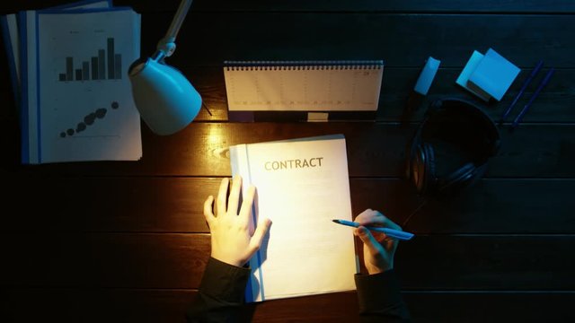 A man is sitting at an office desk and using a phone.