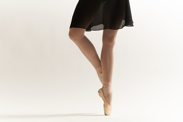 the ballerina is standing on her toes in pointe shoes with one leg to the side