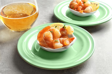 Plate with bacon-wrapped shrimps on table