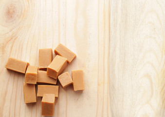 Sweet caramel candies on wooden background