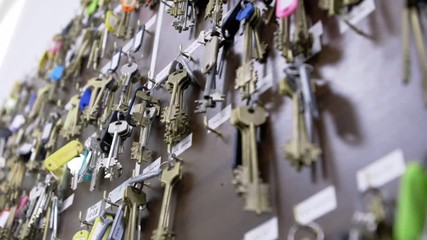 Wall with many rows of keys with numbers, labels and stickers in dispatch of residential complex
