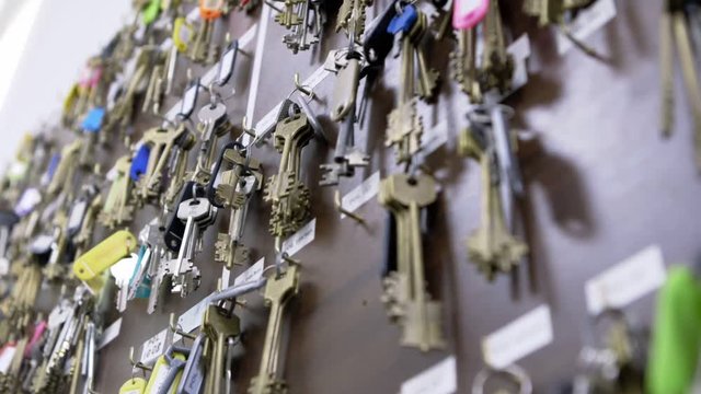 Wall with many rows of keys with numbers, labels and stickers in dispatch of residential complex