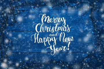 Garlands on a blue background. The inscription is added Merry Christmas and Happy New Year