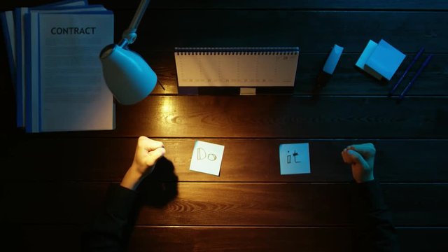 A man is sitting at an office desk and using a phone.