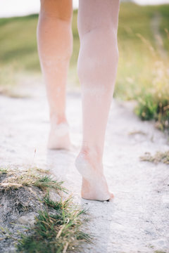 Young beautiful woman's legs walking by the path on a chalk mountain