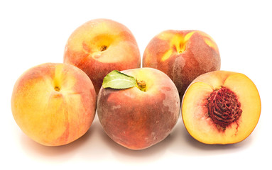 Group of whole peaches and one sliced half with a stone isolated on white background.