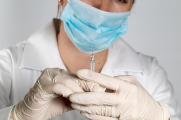 Close up of a female doctor or nurse preparing an injection or vaccine