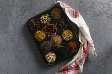 Indian Spices / Masala Box on a Gray Background. With a Kitchen Cloth.