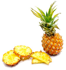 Fresh sliced pineapple and one whole with green leaves isolated on white background.