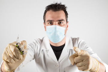 Doctor with many syringes ready to give vaccine injections. Young man in doctor outfit with a lot...
