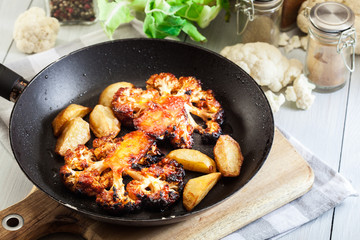 Vegetarian roasted cauliflower steak with herbsand fried potatoes