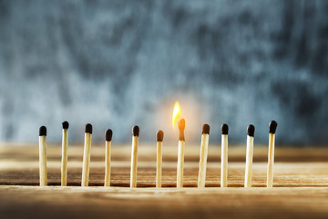 matches stand in a row, one match burns.
