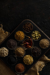 Obraz na płótnie Canvas Indian Spices / Masala Box on a Black Background. With Jute.