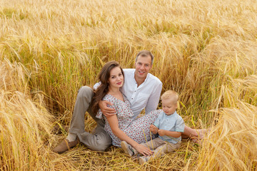 Family sitting on the grass in a wheat field