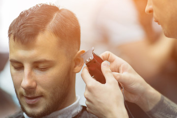 Naklejka premium Young handsome man in barbershop