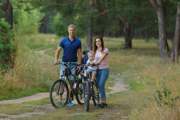 Naklejka na ściany i meble Bicyclist family, leisure in pine forest