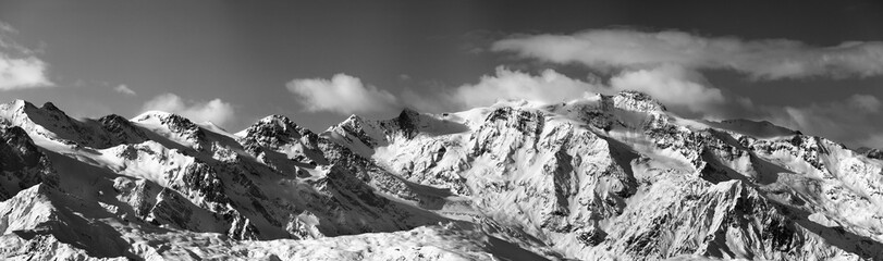 Black and white panoramic view on snowy mountains